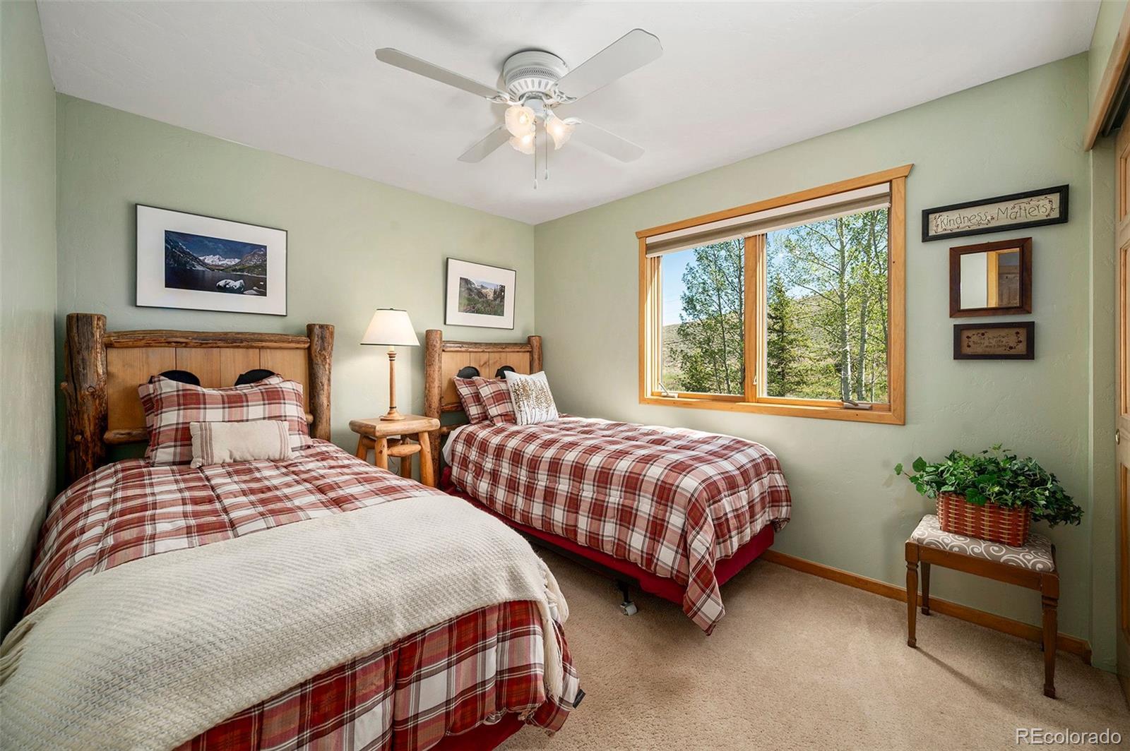 290 Village Road Granby, CO 80446 - Photo 22 of 45 a bedroom with two beds and a chandelier