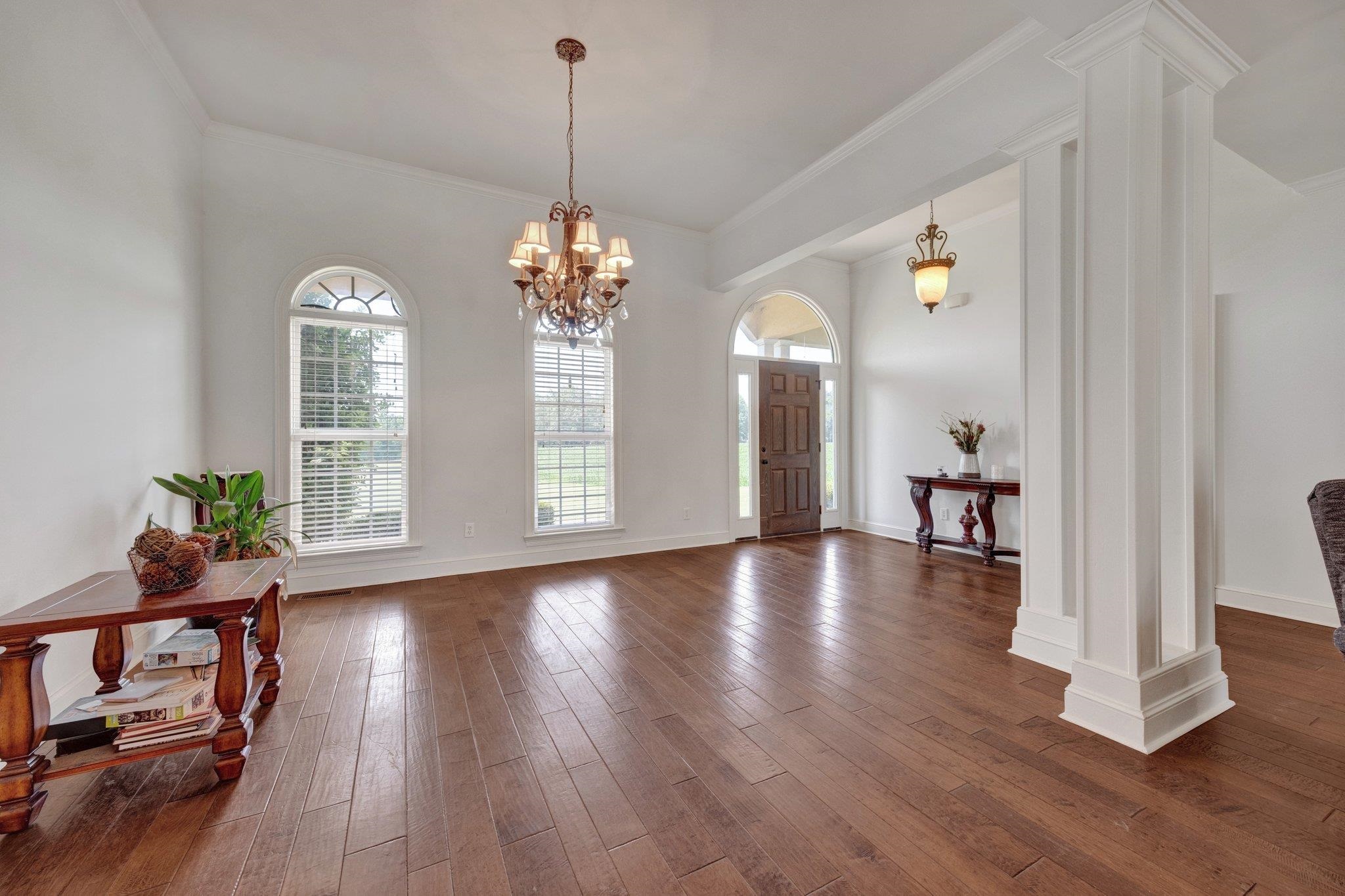 a view of a room with wooden floor potted plant and windows