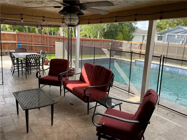 a view of a patio with a table chairs and a backyard