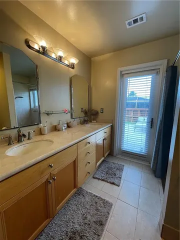 a spacious bathroom with a double vanity sink and a mirror