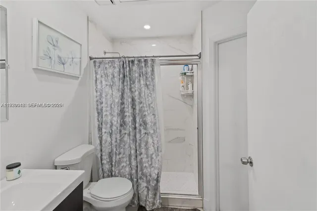 a bathroom with a toilet a sink and shower