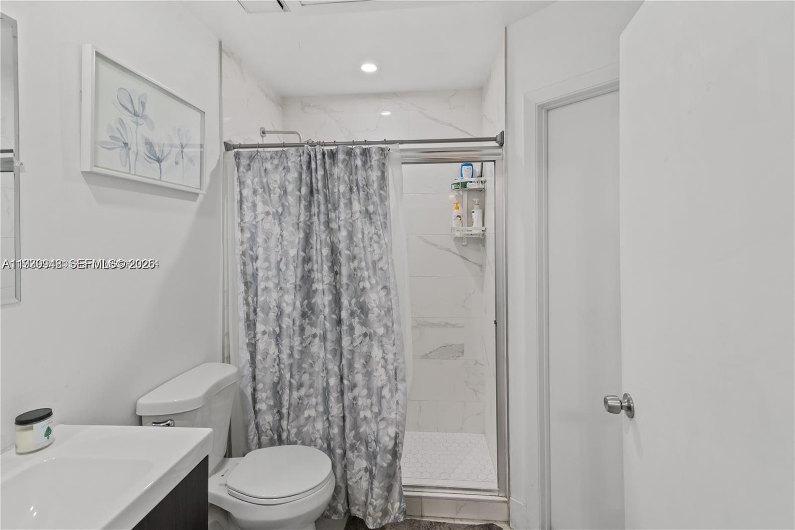 18348 Northwest 68th Avenue, Unit D Hialeah, FL 33015 - Photo 15 of 18 a bathroom with a toilet a sink and shower