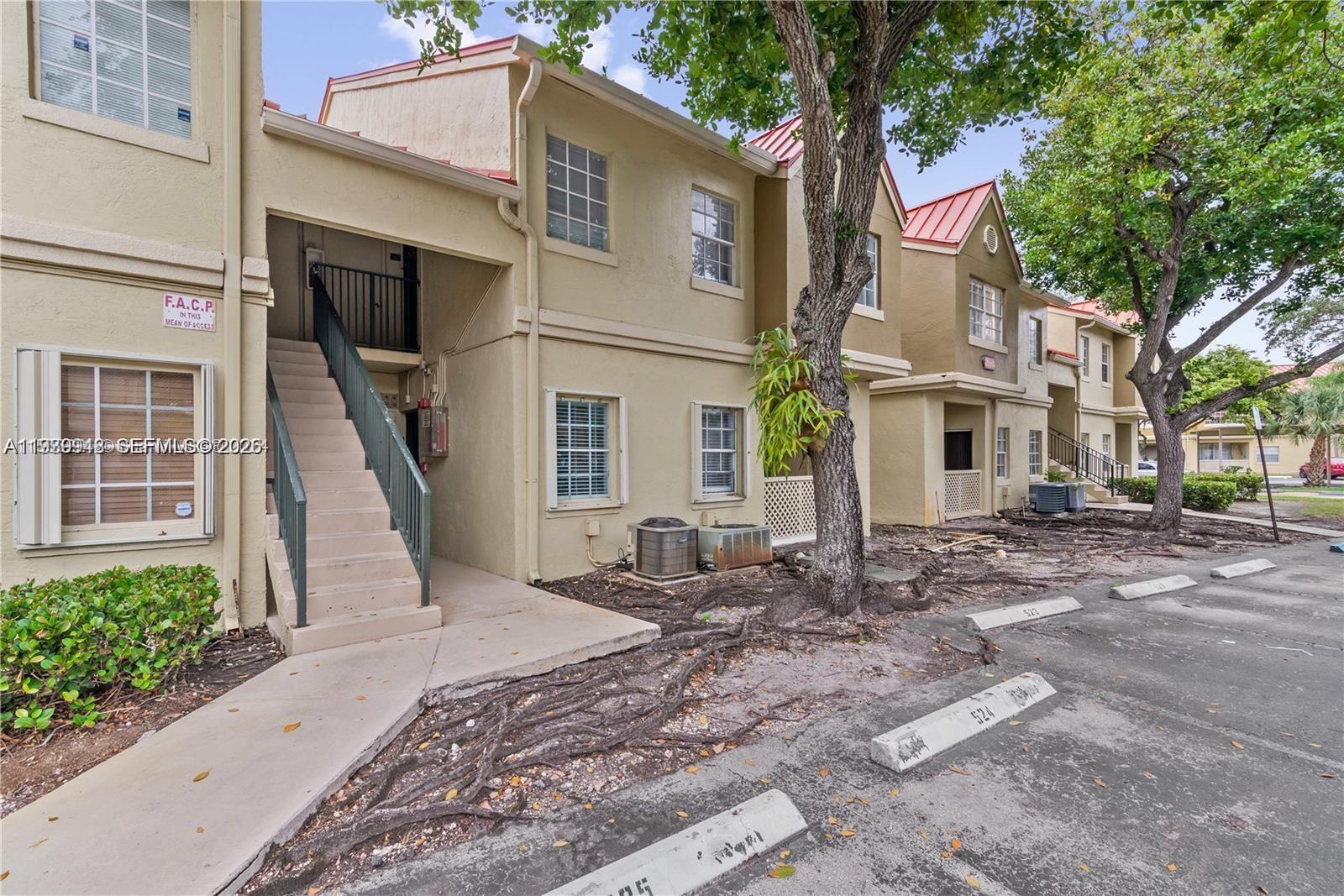 18348 Northwest 68th Avenue, Unit D Hialeah, FL 33015 - Photo 2 of 18 a front view of a house with garden