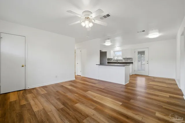 a view of kitchen with granite countertop cabinets and refrigerator