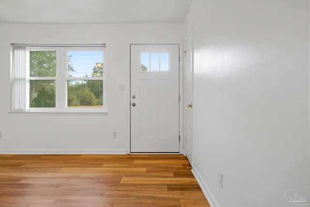 a view of a room with wooden floor and a ceiling fan
