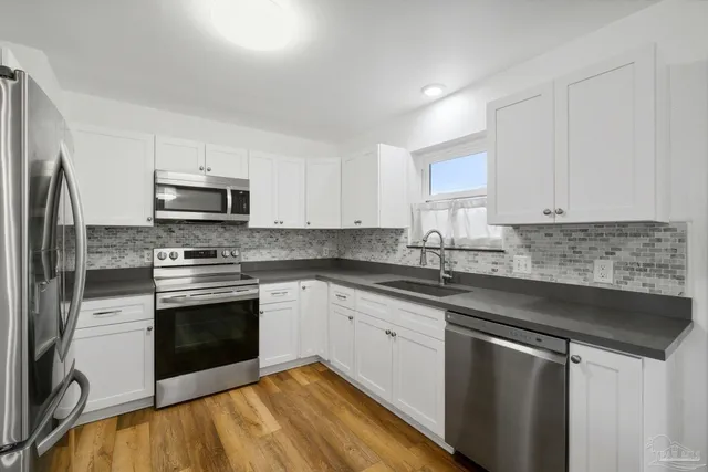 a kitchen with stainless steel appliances granite countertop a stove a sink and a microwave