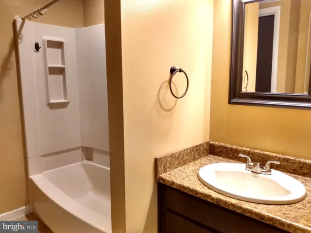 a bathroom with a granite countertop sink and a mirror