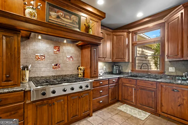 a kitchen with stainless steel appliances granite countertop a sink a stove and a refrigerator