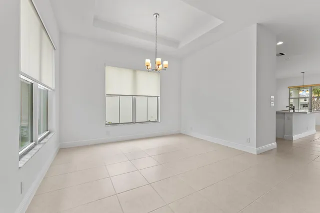 a large white kitchen with stainless steel appliances granite countertop a refrigerator oven a sink dishwasher and white cabinets with wooden floor