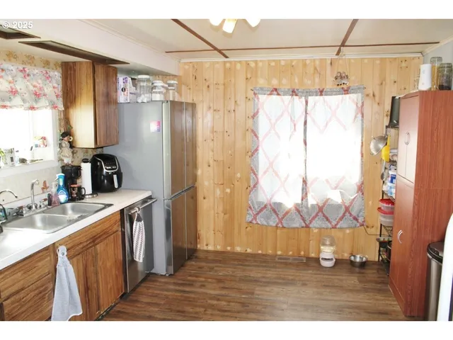 a kitchen with a sink a refrigerator and a window