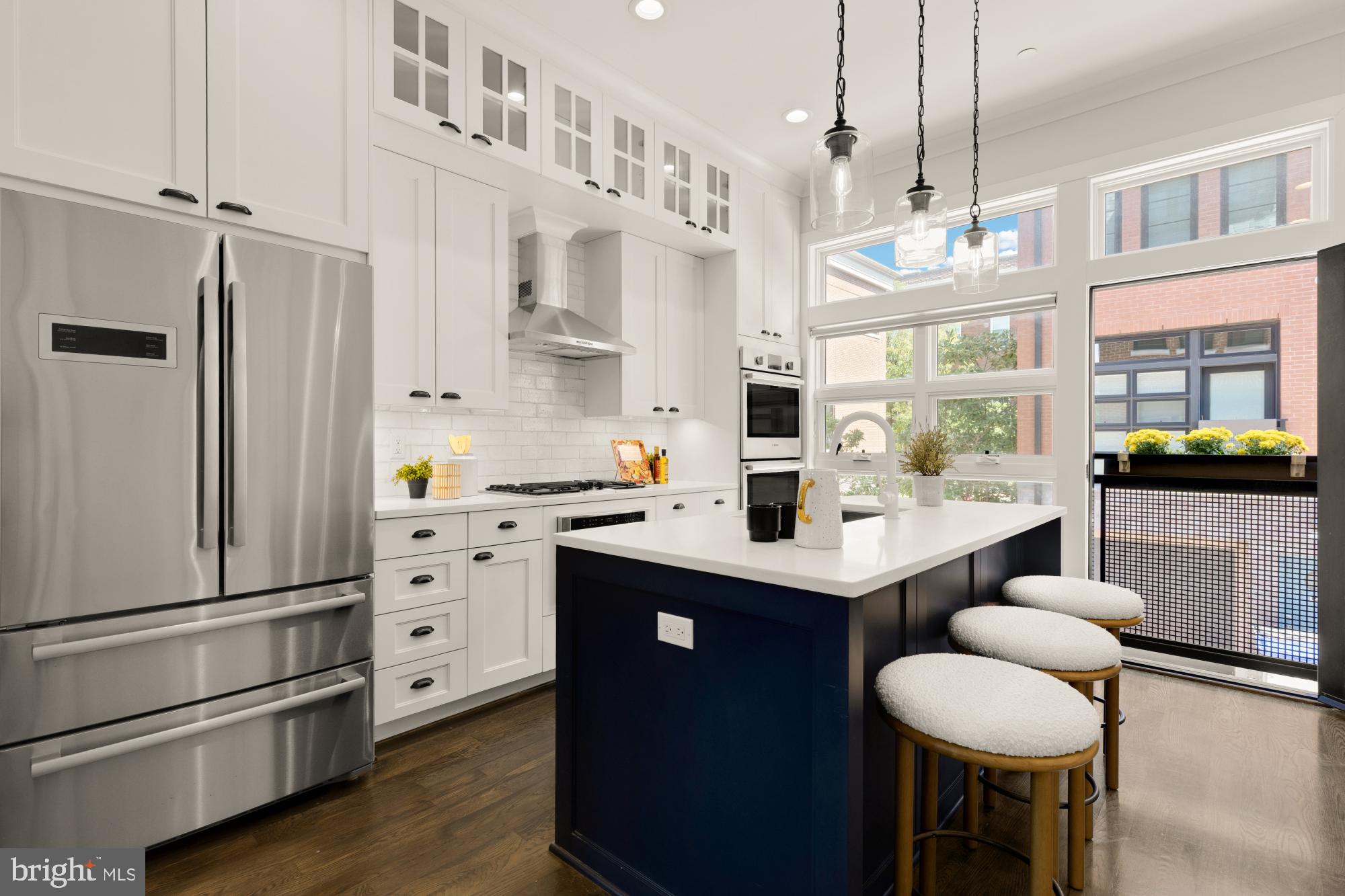 412 13th Street Southeast Washington, DC 20003 - Photo 16 of 62 a kitchen with stainless steel appliances kitchen island granite countertop a refrigerator a stove a dining table and chairs with wooden floor