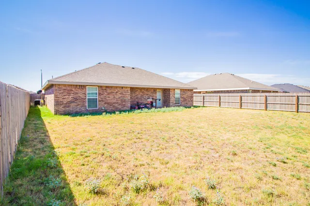 a view of a house with a yard and a fountain