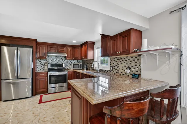 a kitchen with stainless steel appliances granite countertop a sink refrigerator and microwave