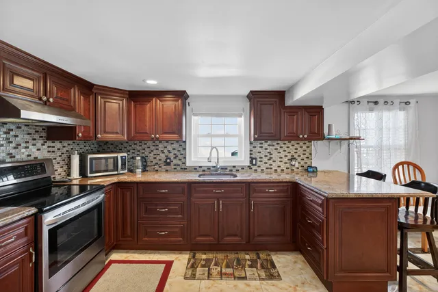 a kitchen with stainless steel appliances granite countertop a sink stove and cabinets
