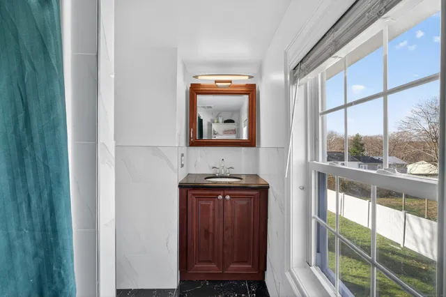 a bed sitting in a bedroom next to a window and a flat screen tv