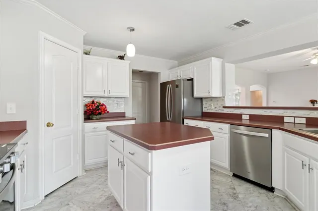 a kitchen with kitchen island granite countertop appliances cabinets and a counter top space