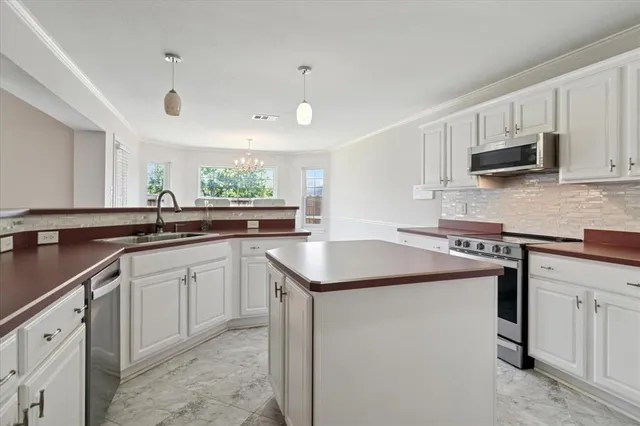 a kitchen with stainless steel appliances granite countertop a sink and dishwasher a stove top oven with wooden floor