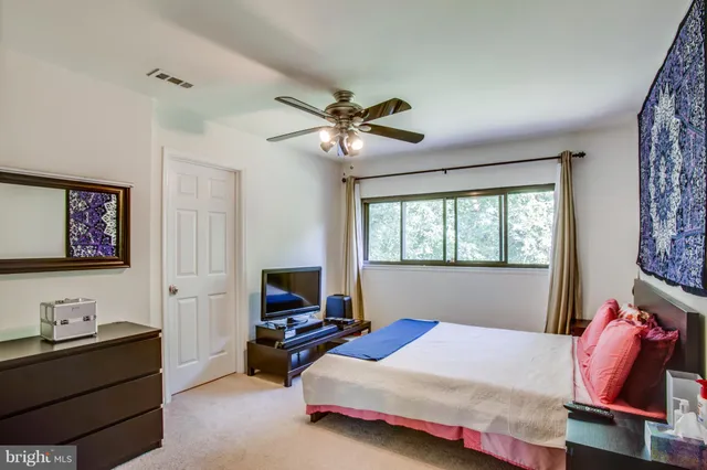 a bedroom with bed tv and window