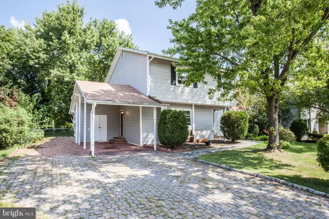 a front view of a house with a yard and potted plants