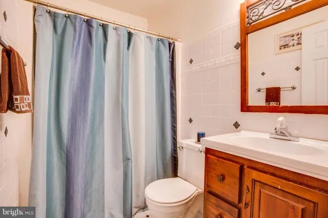 a bathroom with a sink a toilet and shower curtain
