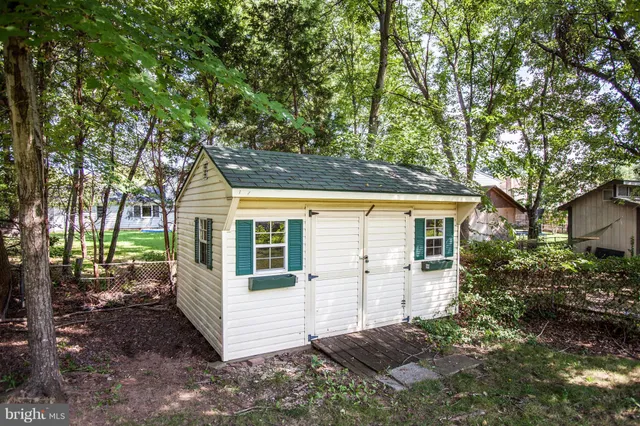 a view of a white house with large windows and a tree