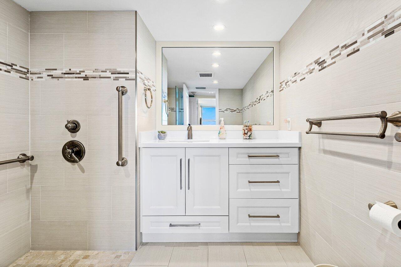 2800 South Ocean Boulevard, Unit 22M Boca Raton, FL 33432 - Photo 12 of 29 a bathroom with a shower a sink and a mirror