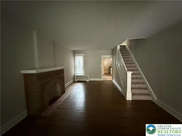 a view of entryway and hall with wooden floor
