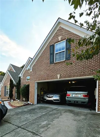 a front view of a house with a parking space