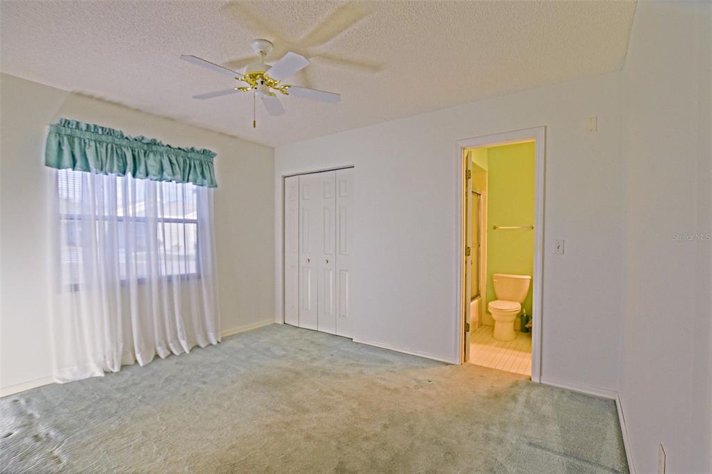 10046 Southeast 175 Street Summerfield, FL 34491 - Photo 21 of 27 an empty room with a window and a ceiling fan