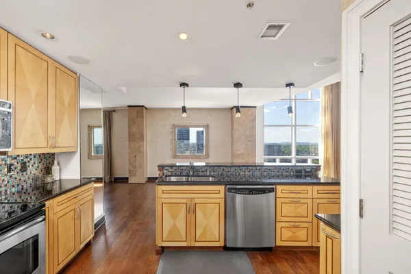 a large kitchen with granite countertop a stove a sink and a granite counter tops with white cabinets