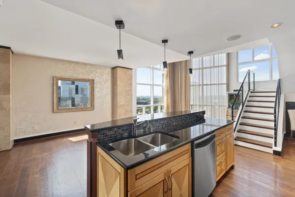 a kitchen that has a sink a window and a dining table with rug