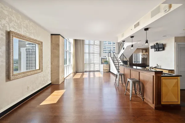 a view of empty room with wooden floor and windows