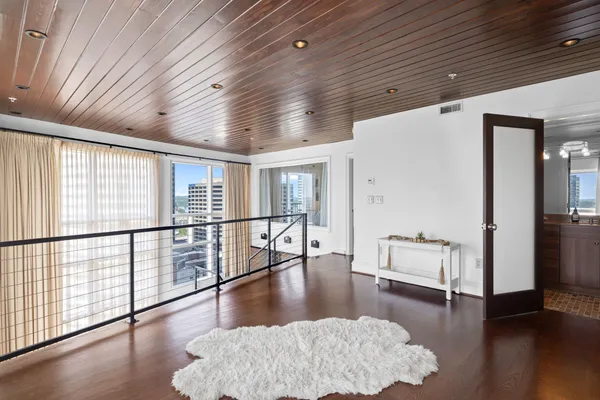 a view of empty room with wooden floor