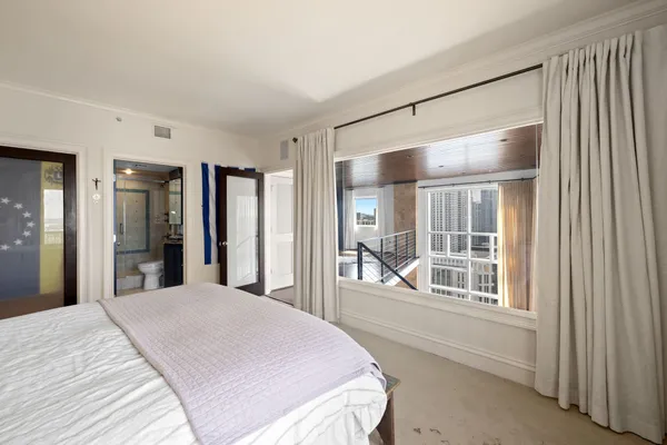 a bedroom with a large bed and a window