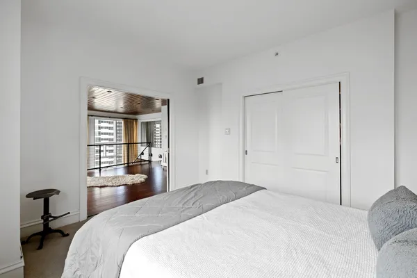 a bedroom with a bed and a large window