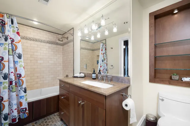 a bathroom with a sink vanity granite tub and shower