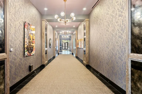 a view of a hallway with a large mirror and couches