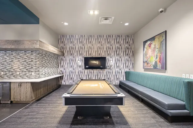 a room with pool table and windows