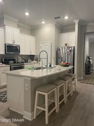 a kitchen with white cabinets a sink and appliances