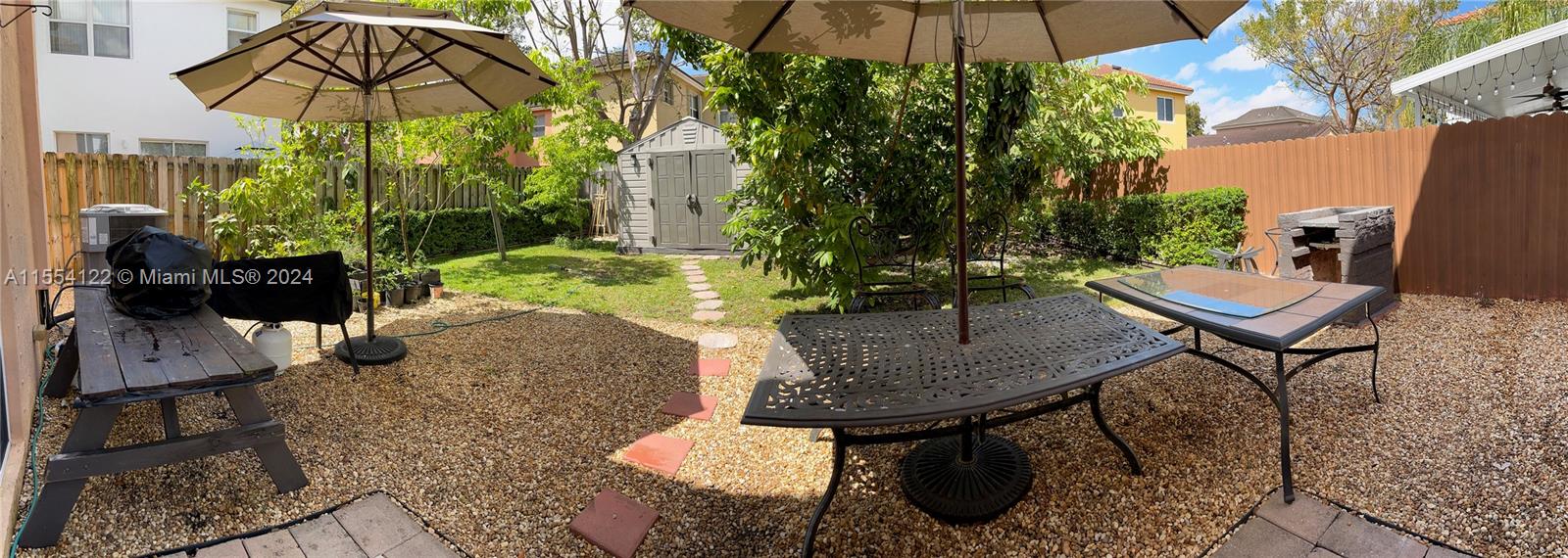 2017 Southeast 15th Street Homestead, FL 33035 - Photo 16 of 20 a backyard of a house with table and chairs under an umbrella