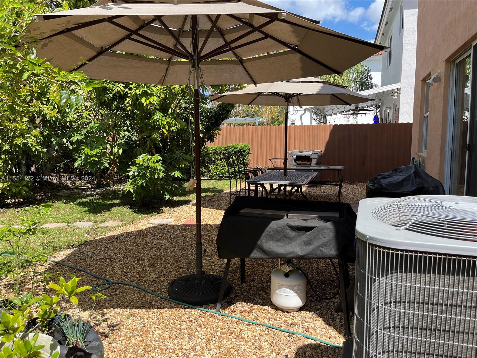 2017 Southeast 15th Street Homestead, FL 33035 - Photo 17 of 20 a patio with a table and chairs under an umbrella