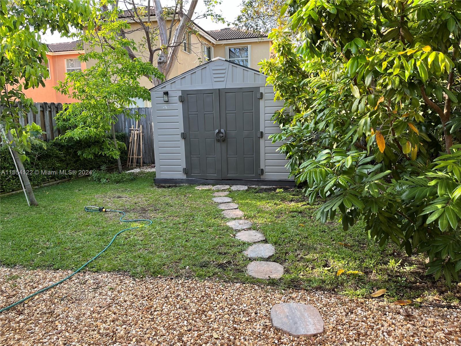 2017 Southeast 15th Street Homestead, FL 33035 - Photo 18 of 20 a view of a backyard with potted plants and large trees