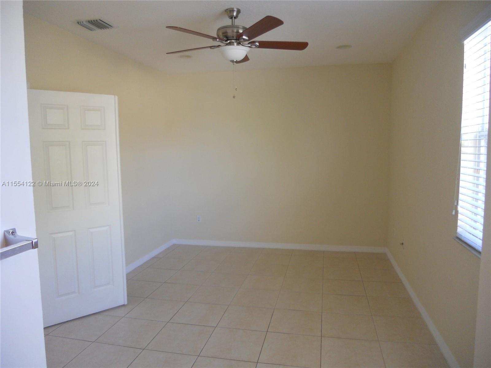 2017 Southeast 15th Street Homestead, FL 33035 - Photo 7 of 20 an empty room with a window and a fan