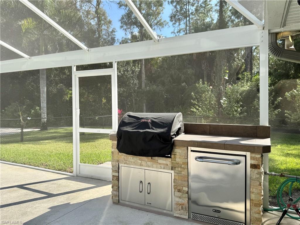 410 6th Street Northeast Naples, FL 34120 - Photo 11 of 32 New outdoor kitchen with grill, refrigerator and storage.