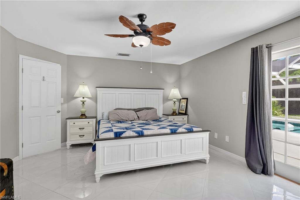 410 6th Street Northeast Naples, FL 34120 - Photo 25 of 32 Master bedroom features double french doors leading to pool area.
