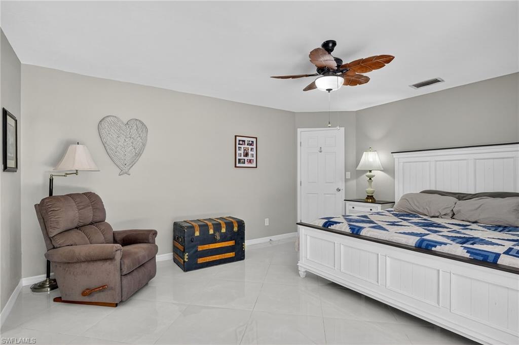 410 6th Street Northeast Naples, FL 34120 - Photo 26 of 32 Master bedroom with ceiling fan, two closets and marble floors.