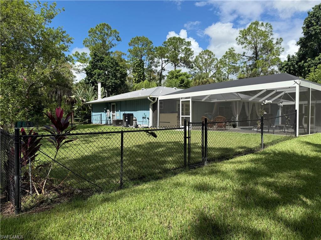 410 6th Street Northeast Naples, FL 34120 - Photo 6 of 32 New side fenced yard off living room and pool area.