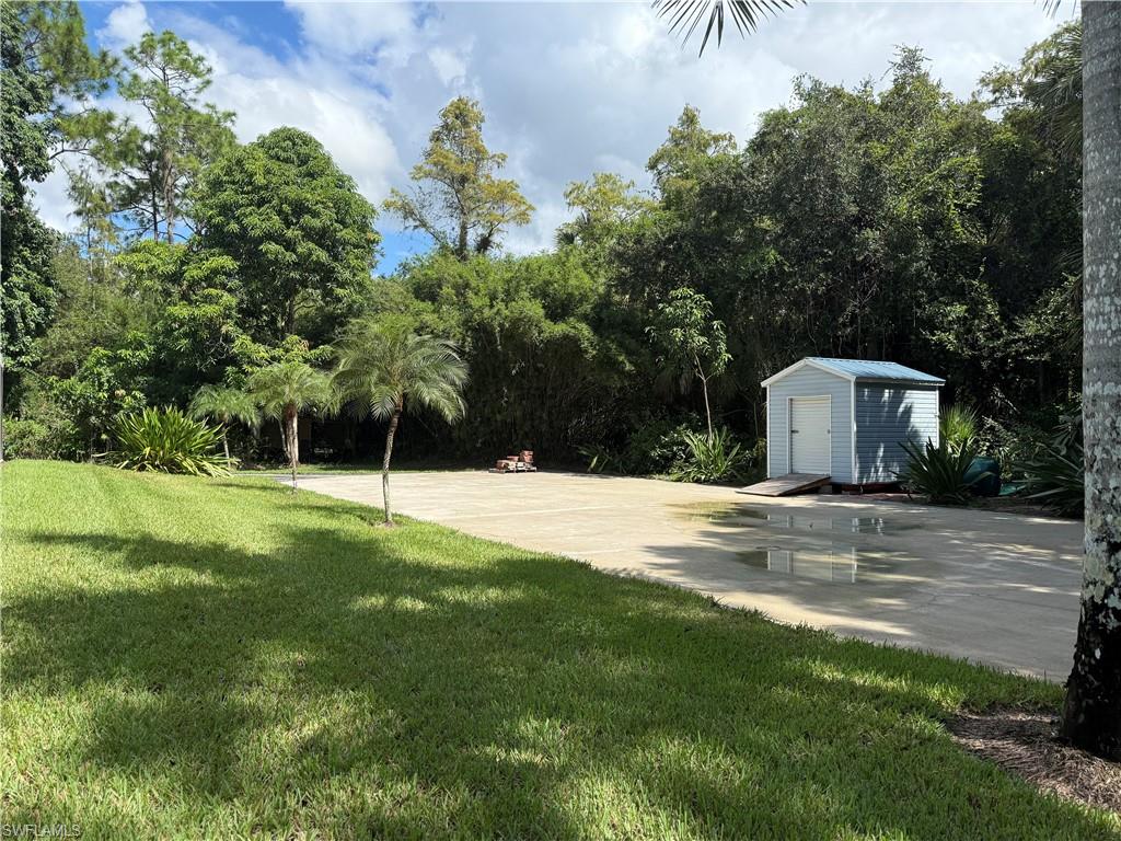 410 6th Street Northeast Naples, FL 34120 - Photo 9 of 32 Rear circle drive/pad for RV/boat/truck parking or optional garage/carport/workshop. Moveable new storage shed.