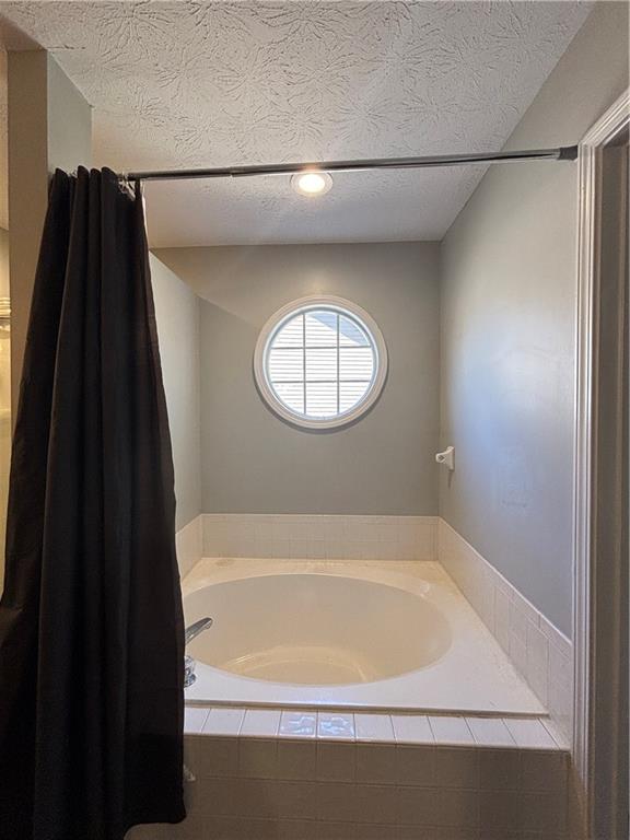 4949 Penscot Way Stone Mountain, GA 30088 - Photo 33 of 40 a bathroom with a bathtub and a shower
