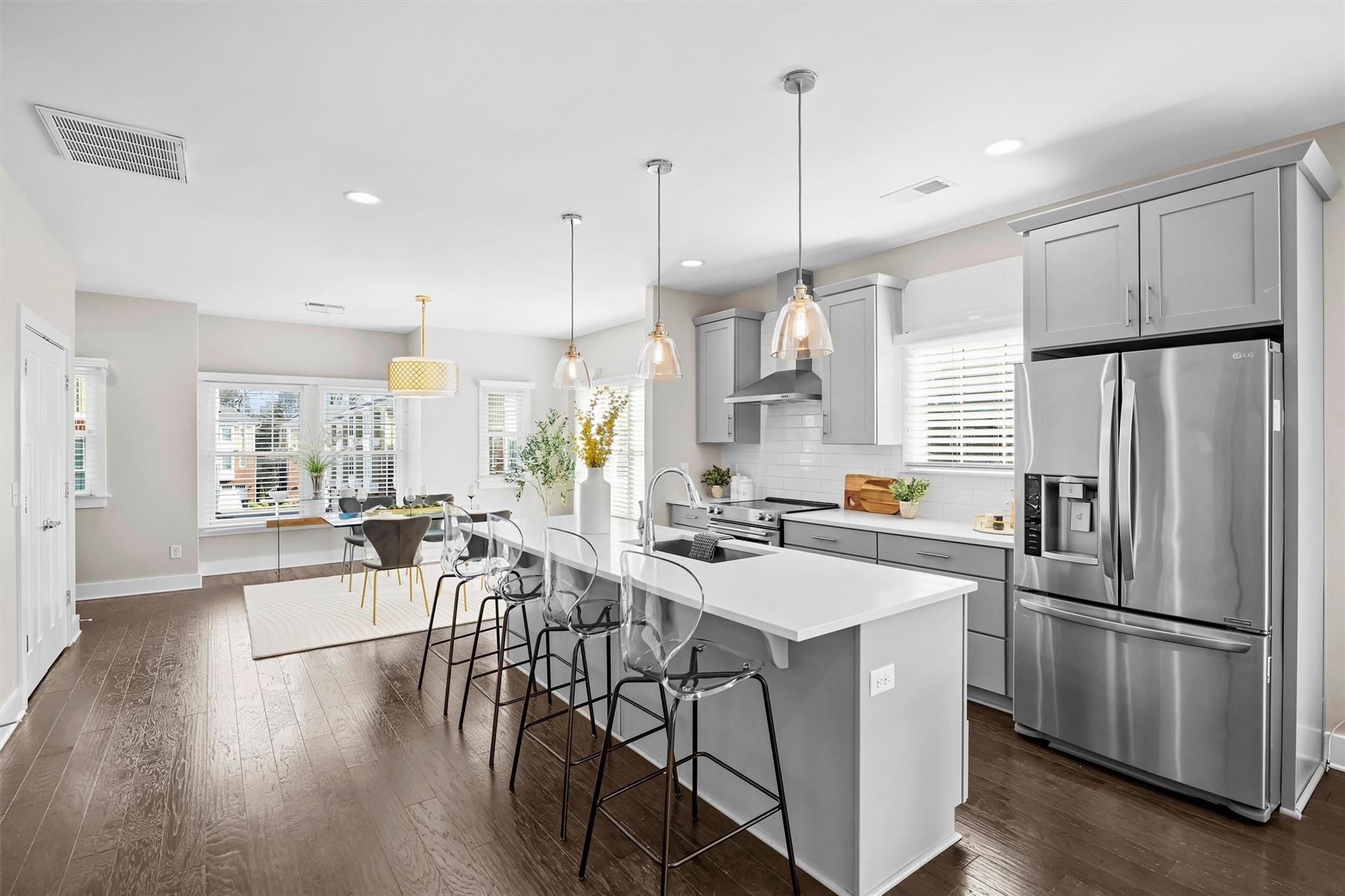 131 Grandin Road Charlotte, NC 28208 - Photo 18 of 45 a kitchen with stainless steel appliances a refrigerator a stove a sink dishwasher a oven and a dining table with wooden floor